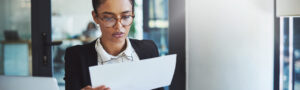 Professional woman reviewing legal or medical documents in an office, representing impartial adjudication and administrative review.