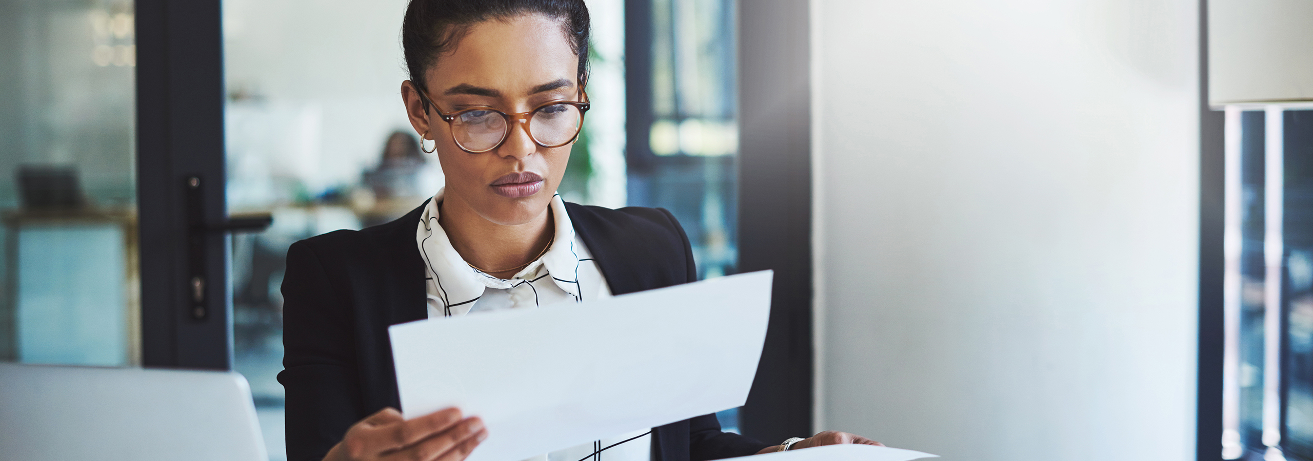 Professional woman reviewing legal or medical documents in an office, representing impartial adjudication and administrative review.