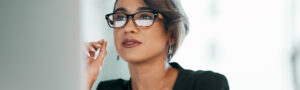 Focused businesswoman with glasses considering CEO strategies for payers and providers to improve Independent Dispute Resolution (IDR) process.
