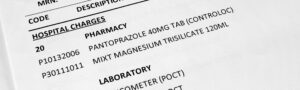 Close-up of hospital charges and medical billing codes for pharmacy and laboratory services, illustrating medical review and payment integrity.