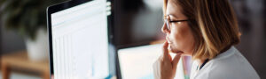 Female professional reviewing data on computer screens, symbolizing CMS guidance, error identification, and dispute closure review.