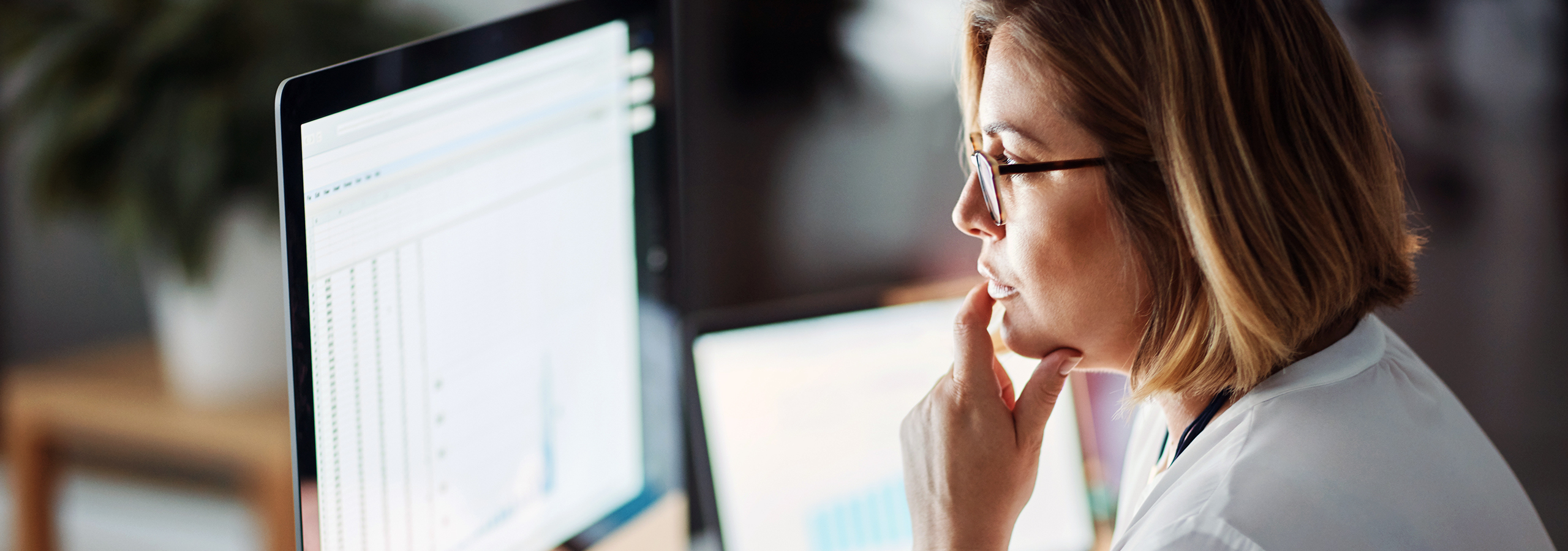 Female professional reviewing data on computer screens, symbolizing CMS guidance, error identification, and dispute closure review.