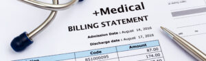 Close-up of medical billing statement with codes and amounts, stethoscope, and pen, representing healthcare costs and insurance claims.