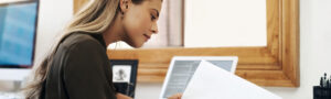 Female professional reviewing certification documents on a laptop, symbolizing FHAS achieving Georgia accreditation as an Independent Review Organization.