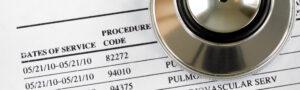 Close-up of medical bill with procedure codes and stethoscope, representing healthcare costs, coding accuracy, and medical review.